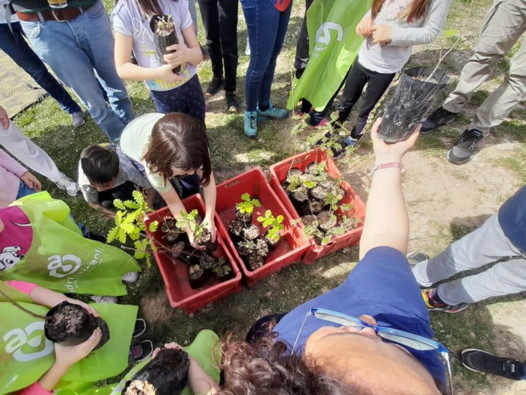 I partecipanti alla piantumazione intorno ad alcune cassette contenenti le piantine da mettere a dimora